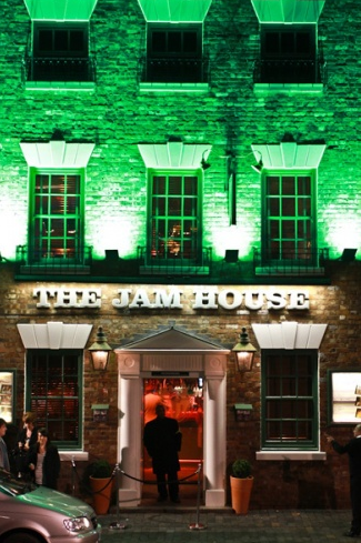 Vibrant Jam House venue with green lighting, ideal for live music and corporate events.