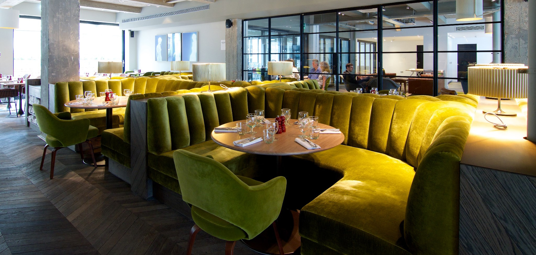 Stylish dining area with velvet seating for exclusive hire events in vibrant green tones.