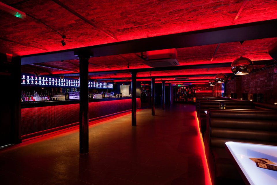 Sleek Baa Bar venue with vibrant red lighting for cocktail receptions and networking events.
