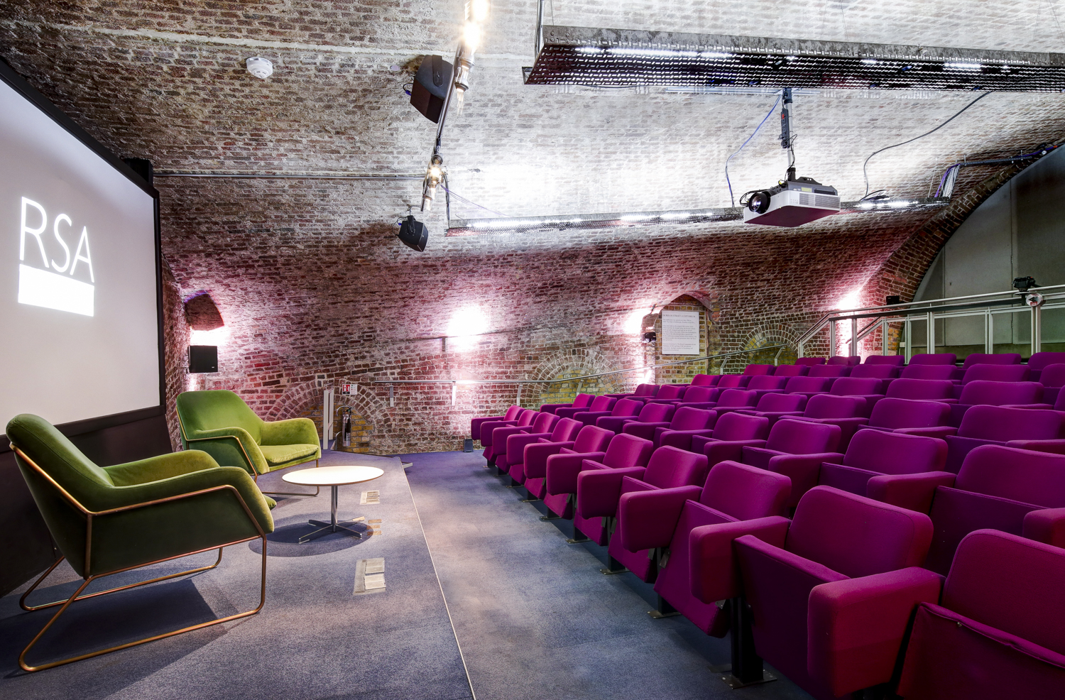 Durham Street Auditorium with modern stage and vibrant purple seating for events.