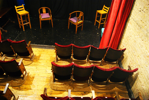 Intimate theater setup with empty chairs for panel discussion at Calder Theatre Bookshop.