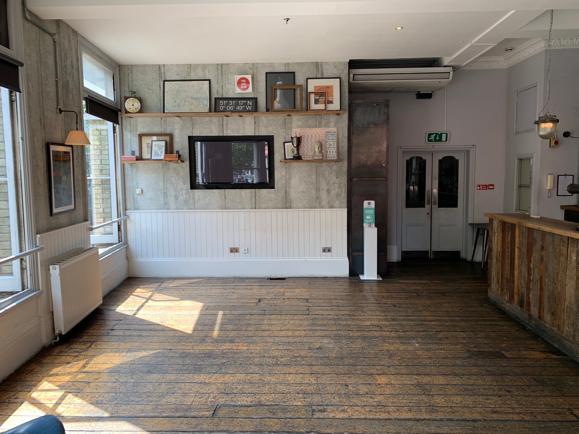 Versatile meeting room with wooden flooring, ideal for events and workshops.