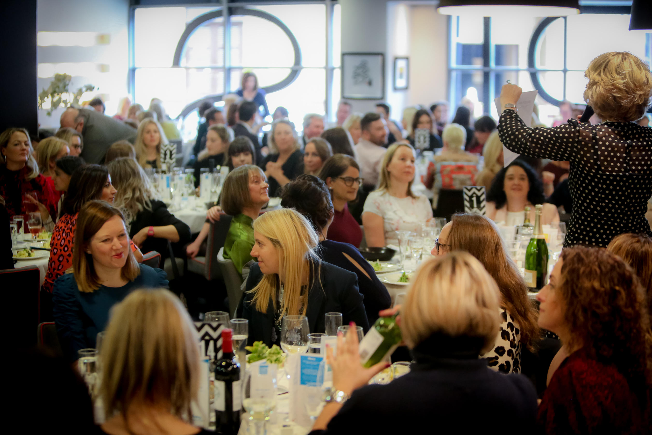 Vibrant networking event at Opus Restaurant with engaged attendees and elegant tables.