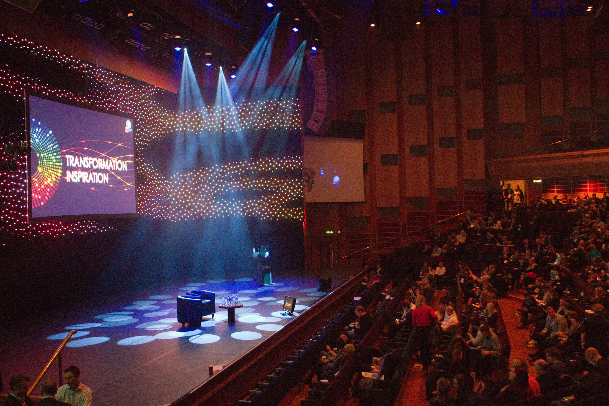 Barbican Hall event space with colorful lighting for a dynamic presentation on "Transformation."