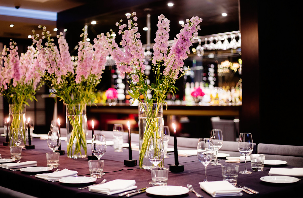 Elegant dining table with floral arrangements at Mal Lounge, perfect for corporate events.
