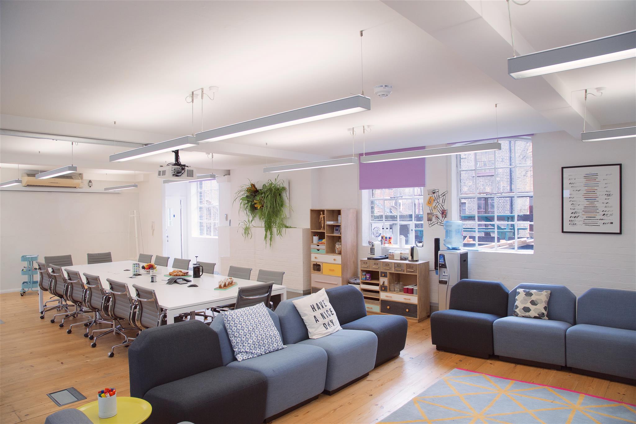 Versatile meeting space with conference table and casual seating for creative events.