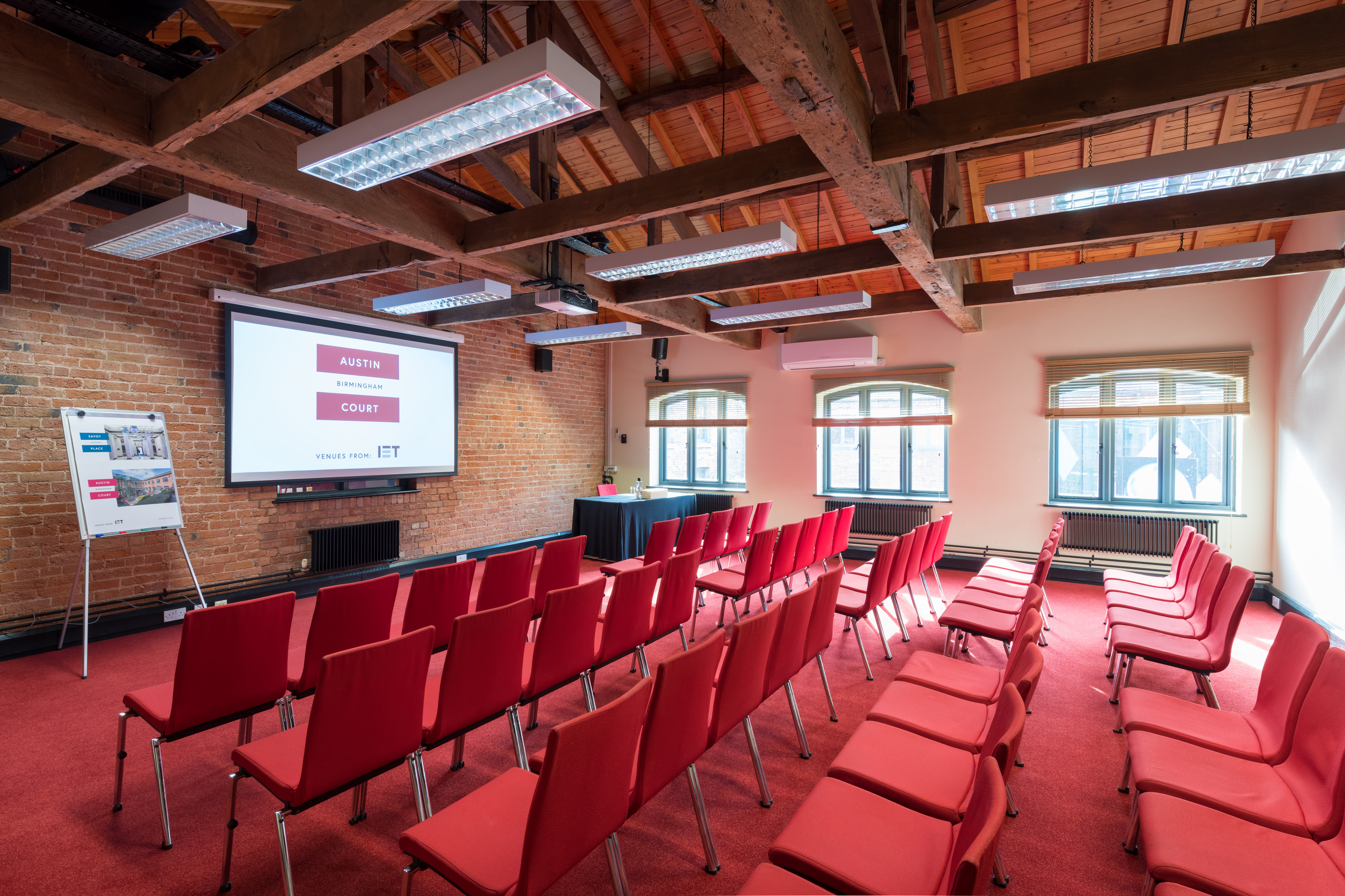 Telford Room at IET Birmingham: modern meeting space with red chairs for workshops.