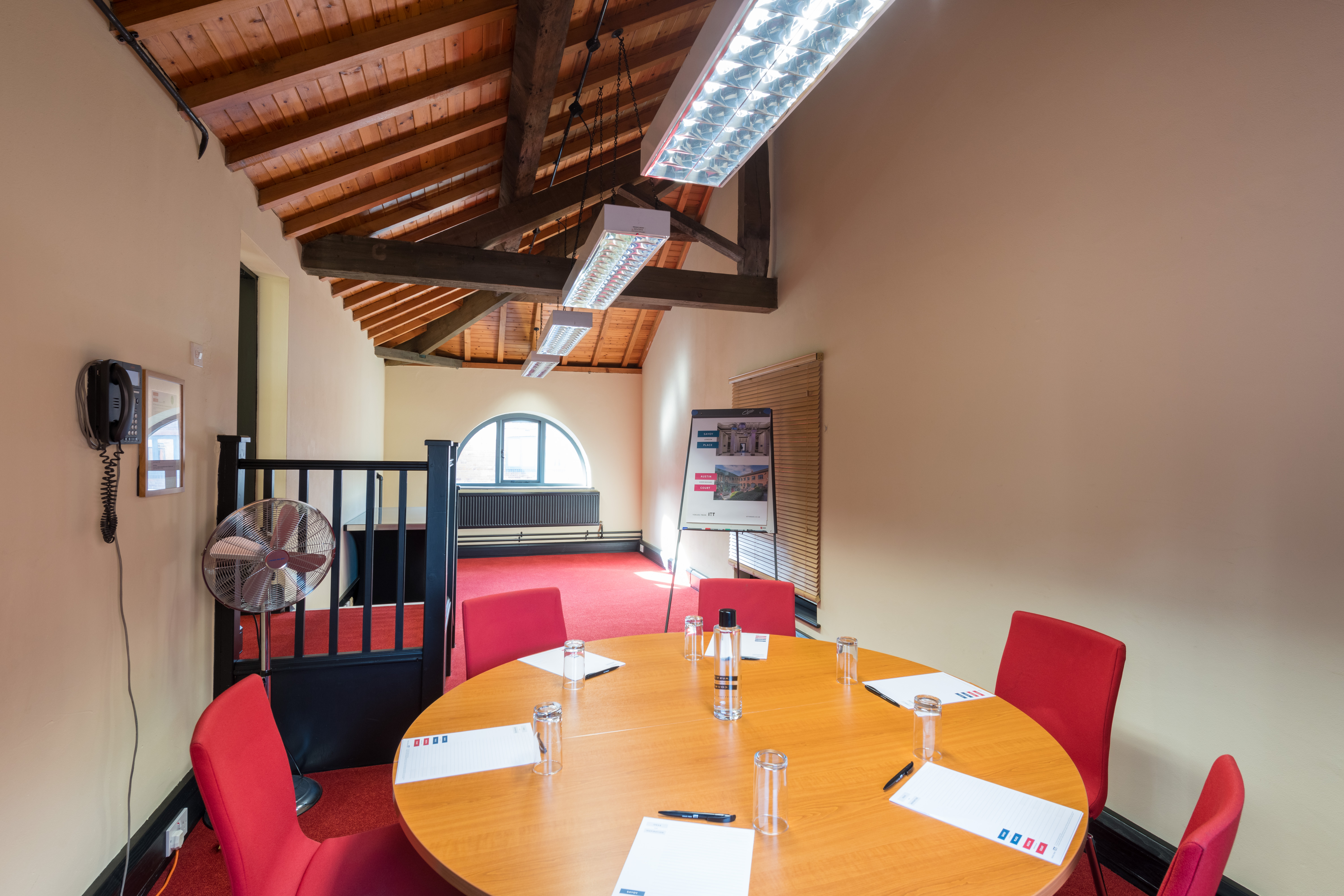 Stephenson Room at IET Birmingham: round table, red chairs, ideal for meetings and brainstorming.