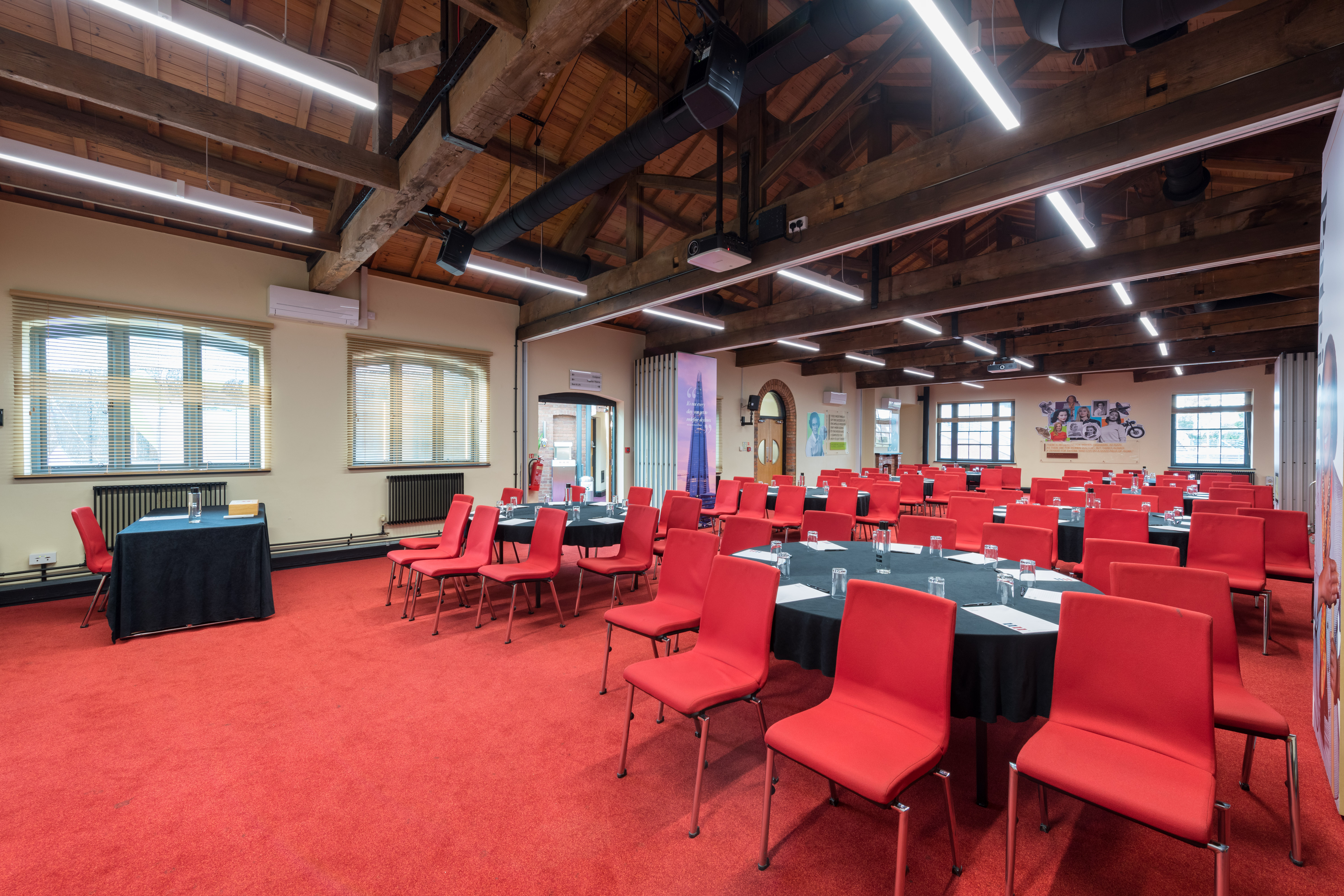 Versatile event space with red chairs and natural light for meetings and conferences.