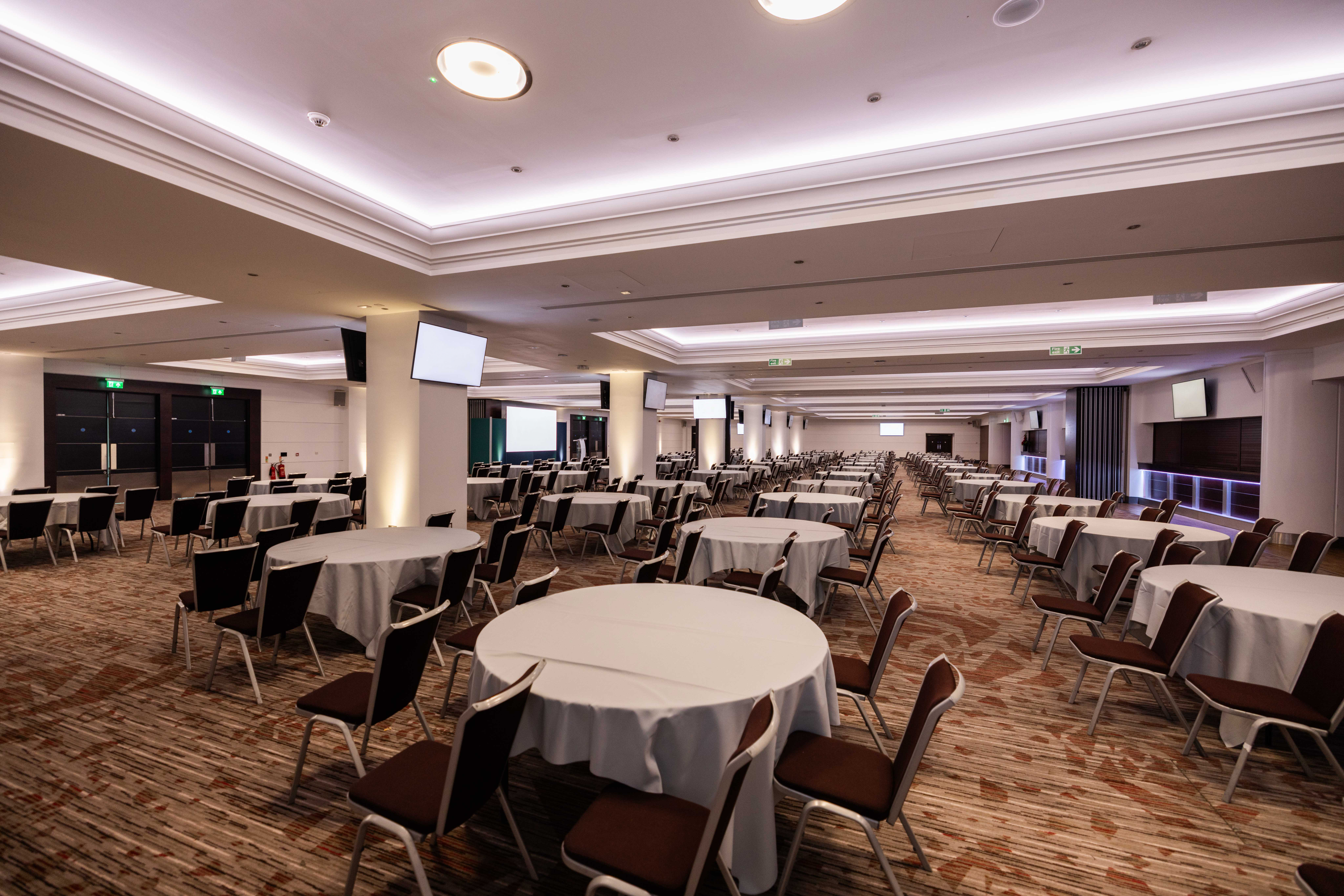 Rose Suite at Allianz Stadium, Twickenham: spacious conference venue with round tables.