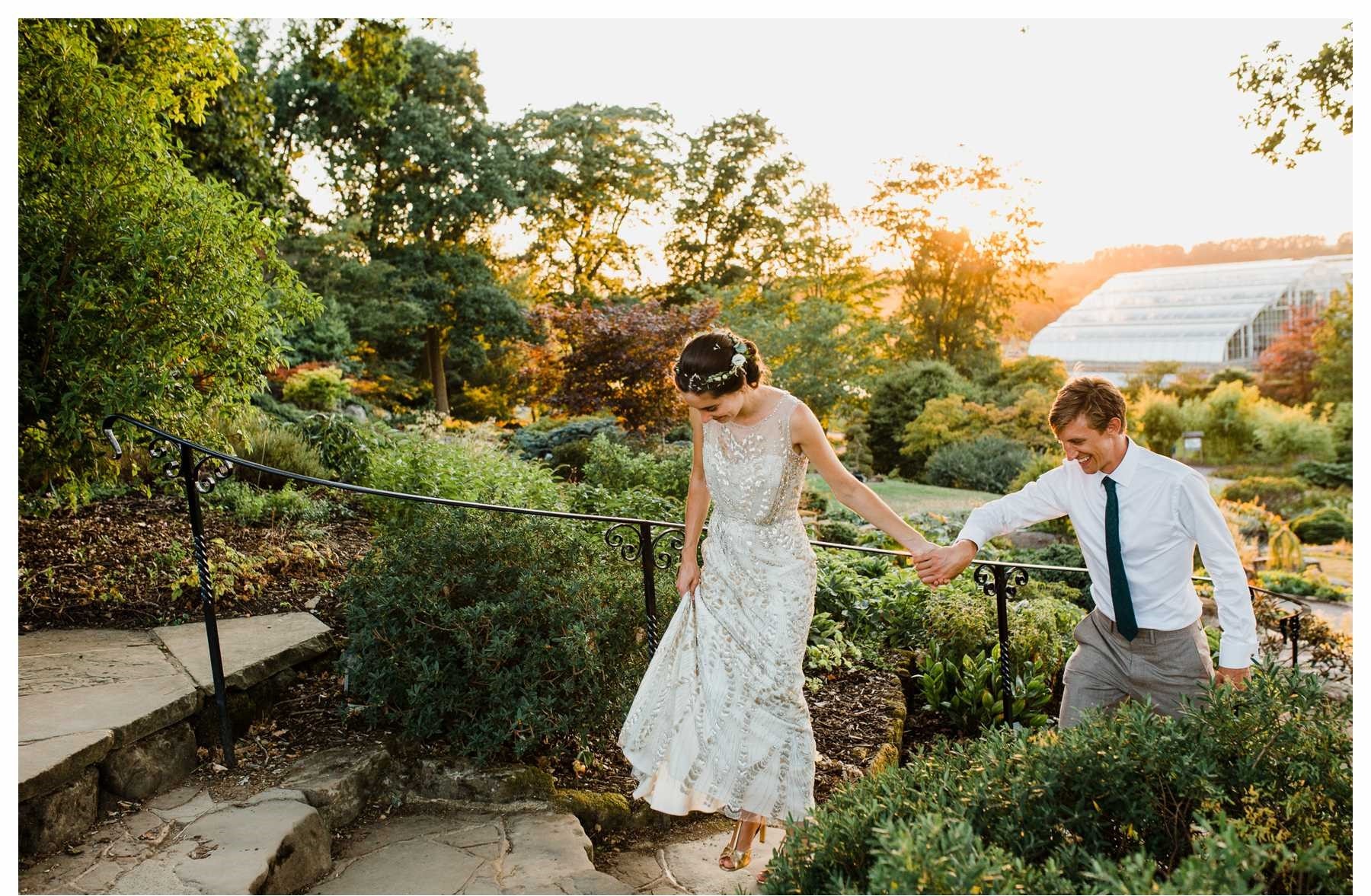 Couple walking in RHS Garden Wisley Glasshouse at sunset, ideal for romantic weddings.