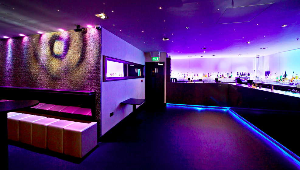 Modern event space with purple lighting, ideal for cocktail receptions and networking.