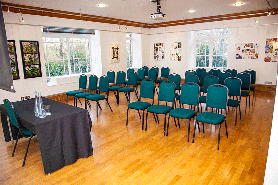 Knapp Gallery meeting space with teal chairs, ideal for workshops and seminars.