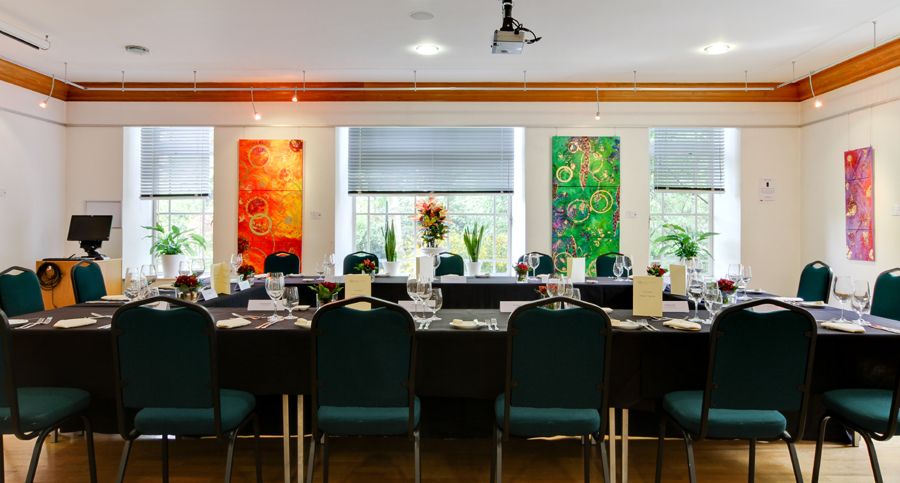 Knapp Gallery meeting room with long table, vibrant art, ideal for events and collaboration.