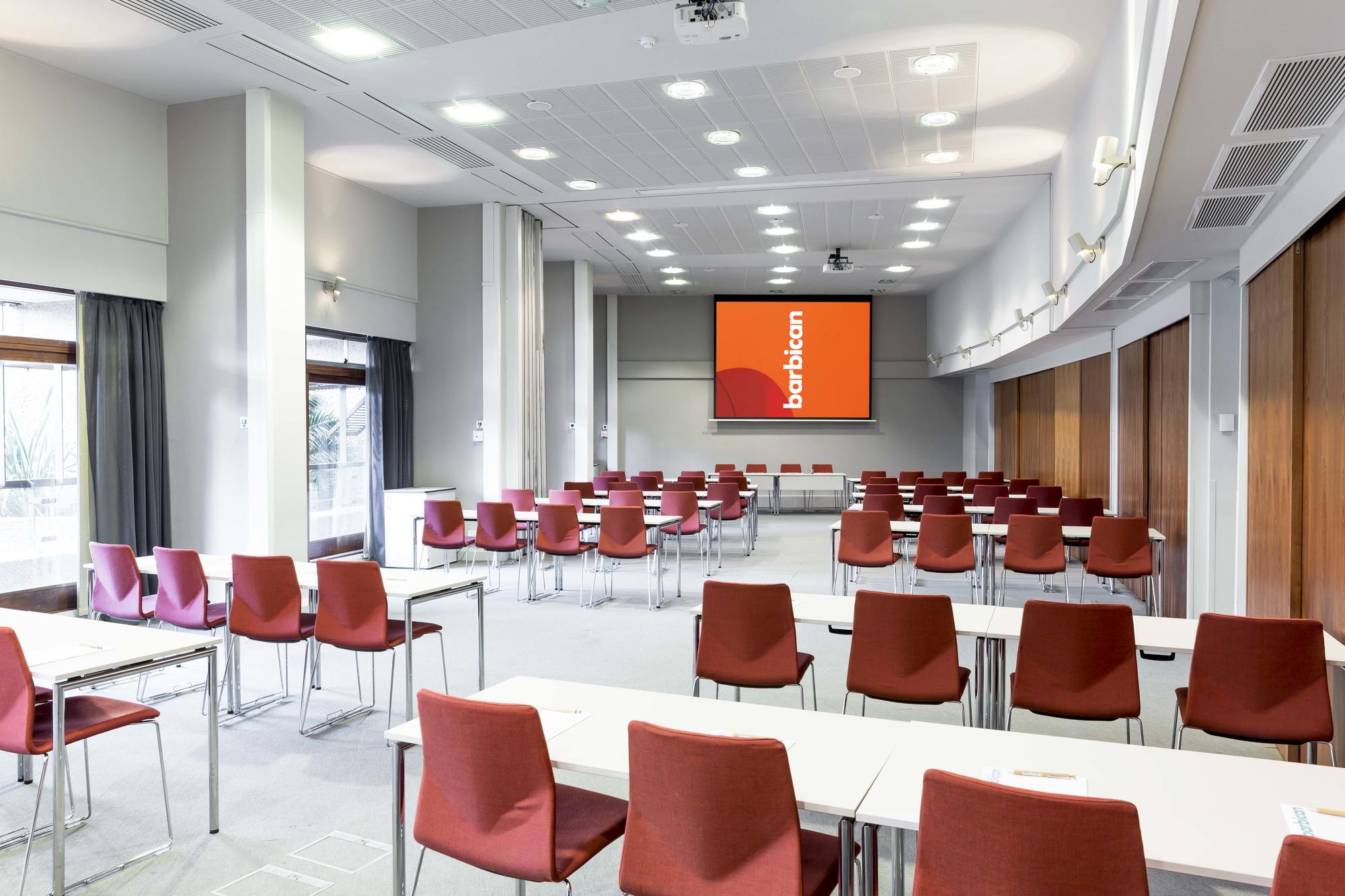Modern meeting room at Barbican Centre, ideal for events with natural light and presentation screen.