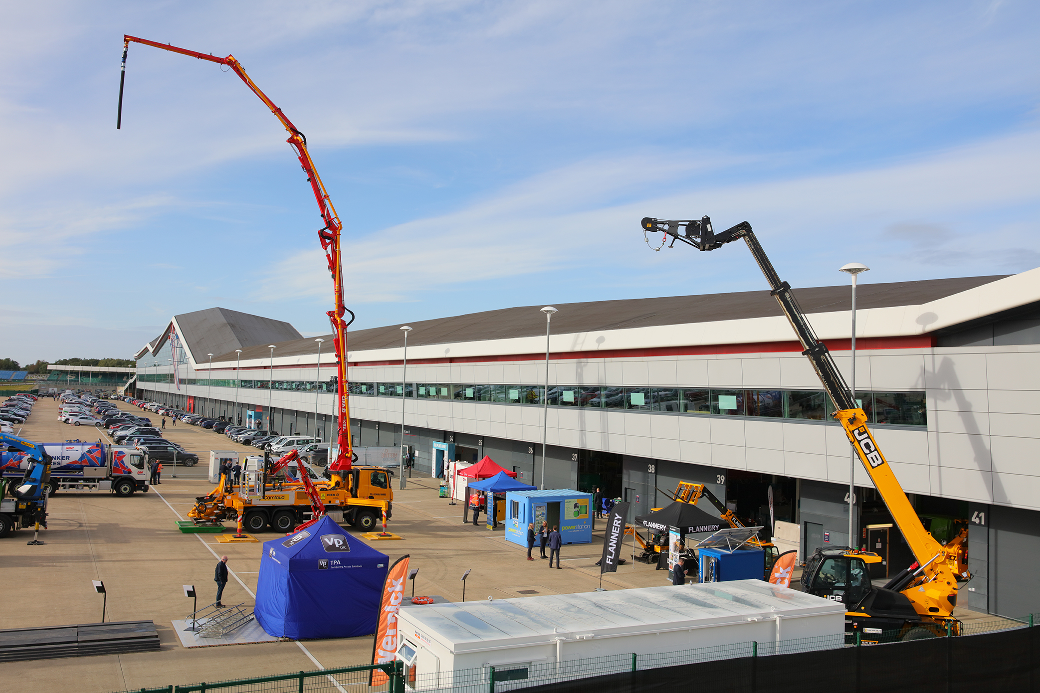 Outdoor industrial event at Silverstone with heavy machinery and networking tents.