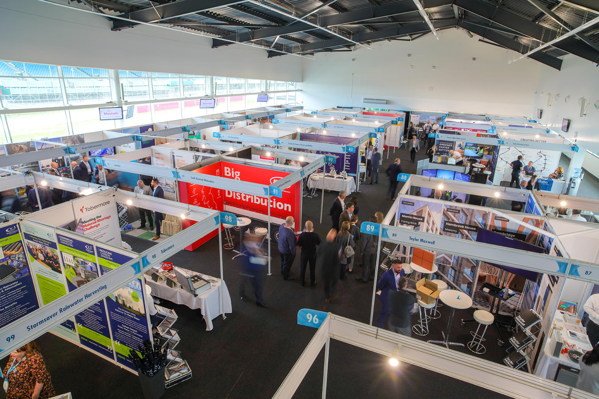 "Silverstone exhibition hall bustling with vendors and attendees networking at a conference."