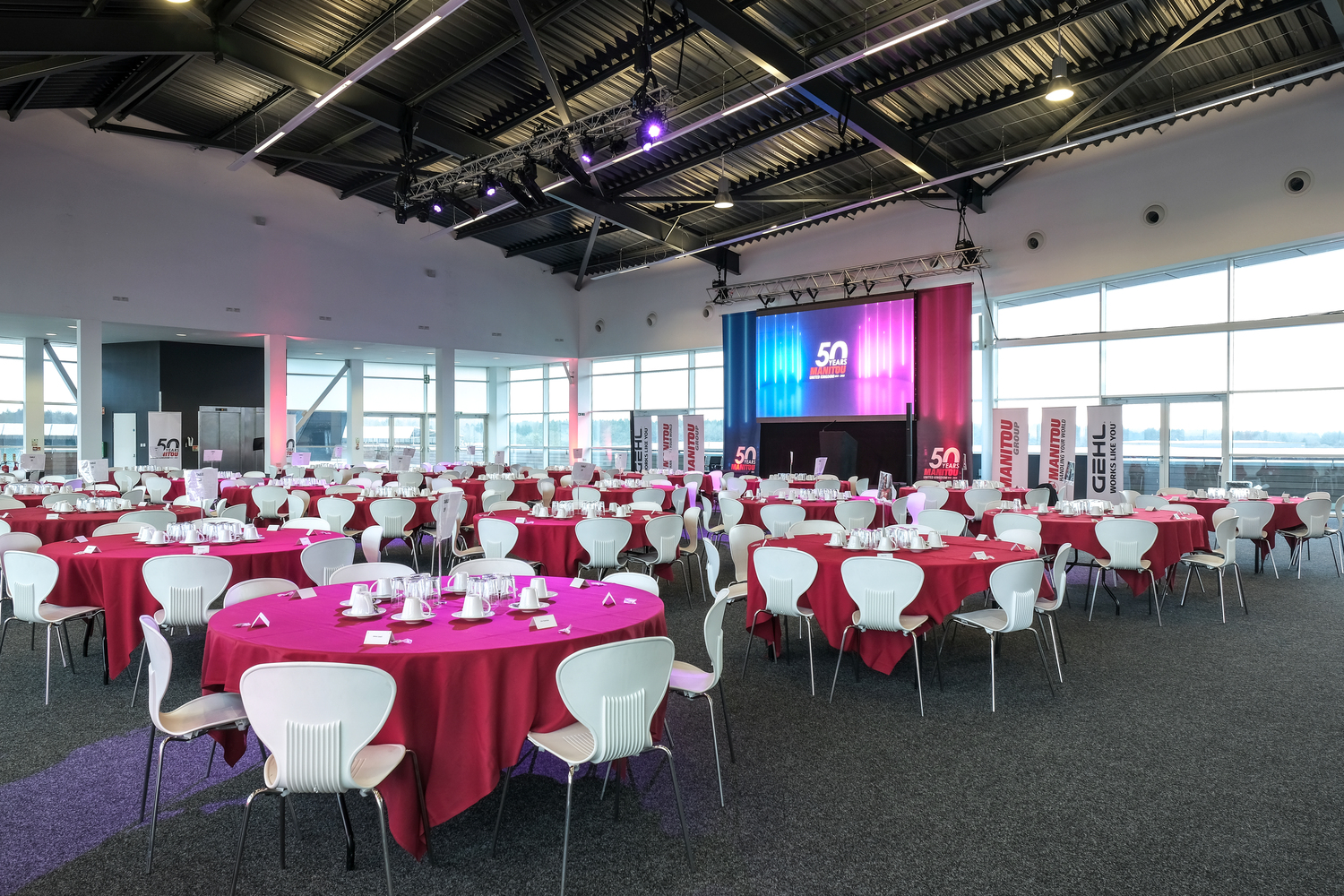Hall 5 at Silverstone: elegant event space with red tables for corporate gatherings.