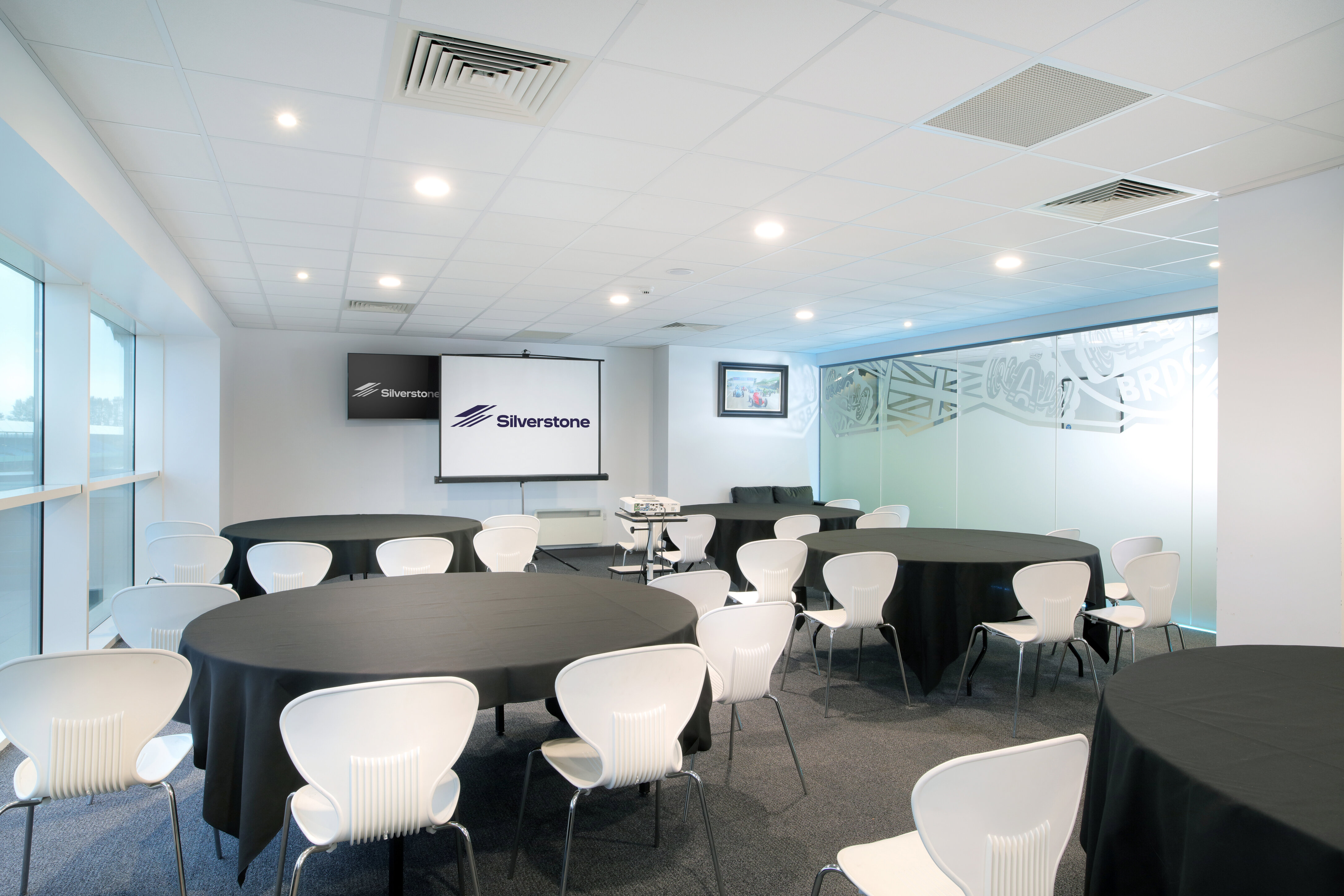 President's Suite at Silverstone: modern meeting space with round tables for corporate events.