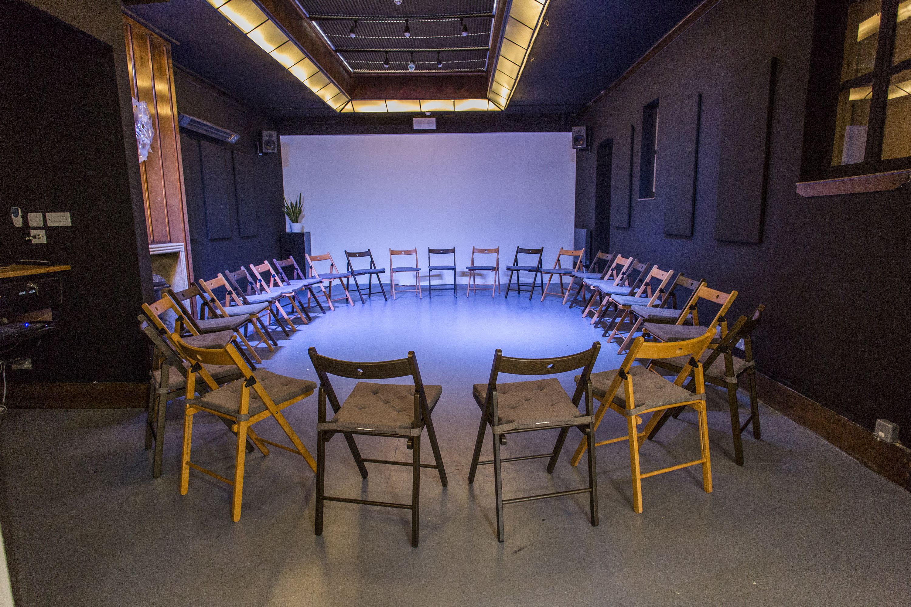 Versatile circular meeting space for workshops with minimalist decor and soft lighting.