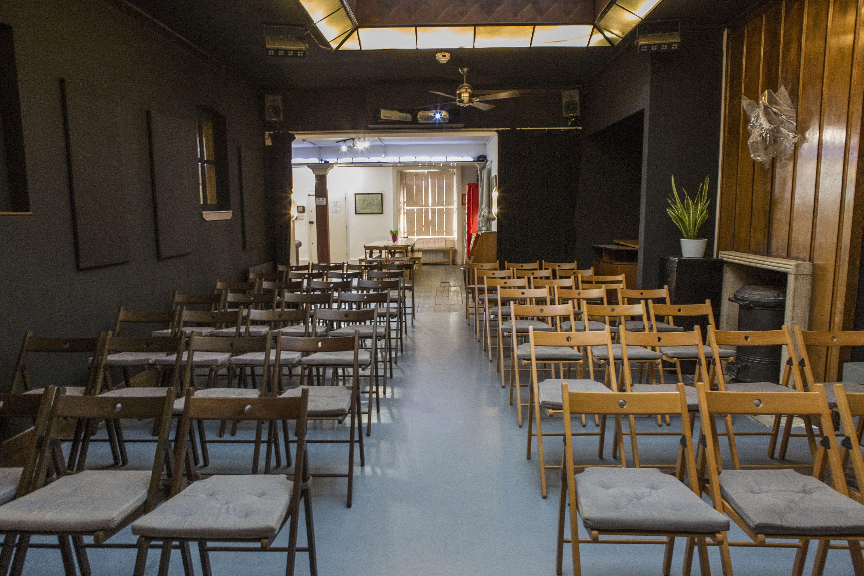 Versatile event space with wooden chairs, ideal for workshops and presentations.