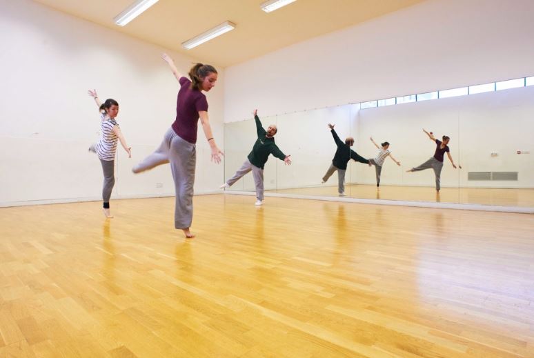 Dance rehearsal in spacious Oxford House studio with mirrored wall, ideal for workshops.