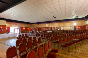 Spacious event venue with red chairs, ideal for meetings and conferences at The Dray.