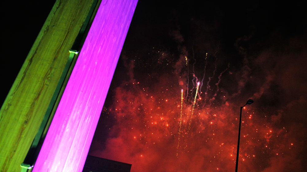 Vibrant Bournville College event with purple lighting and fireworks backdrop.