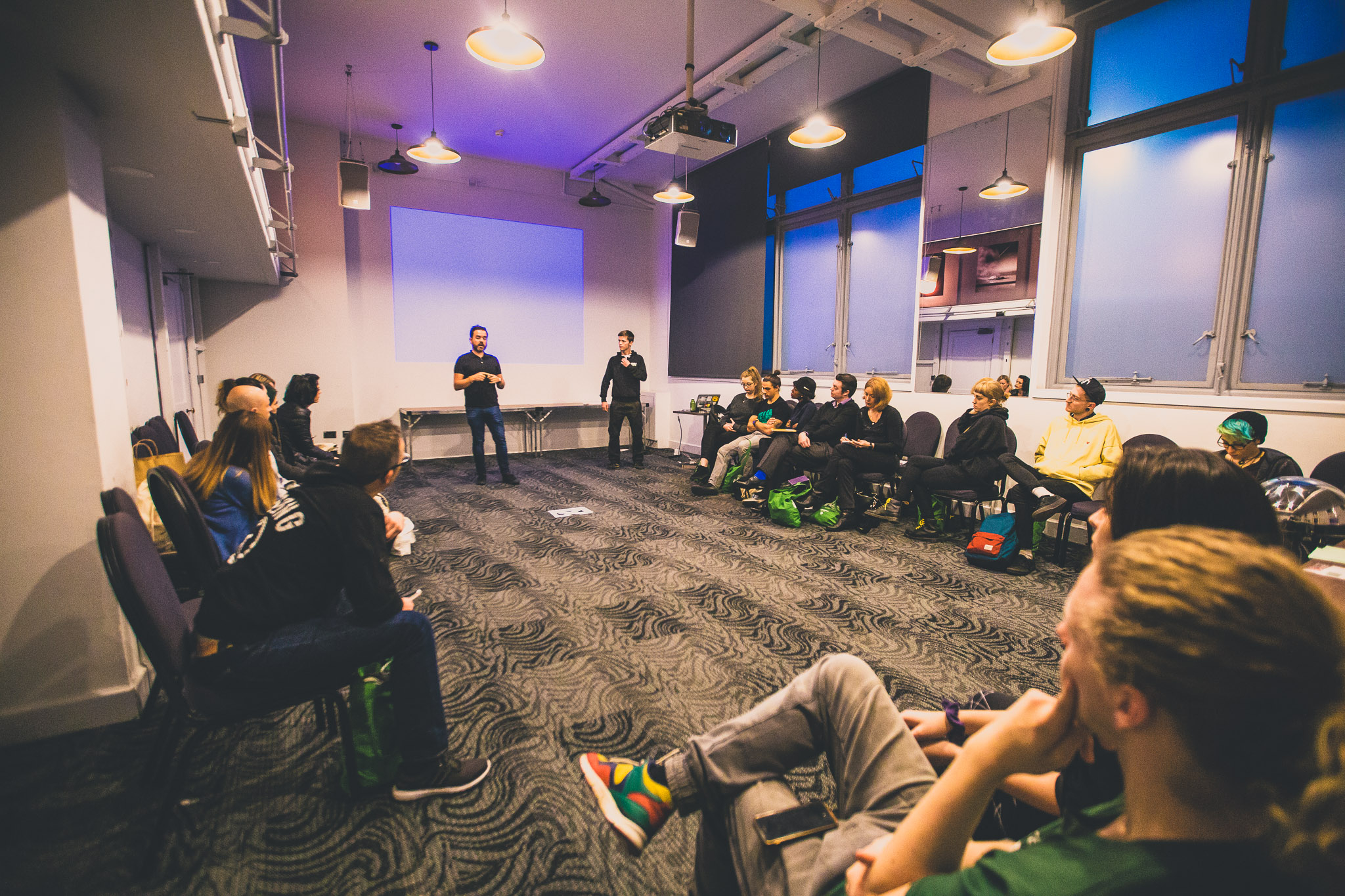 Dynamic workshop space in Royal Institution with speaker engaging attentive audience.