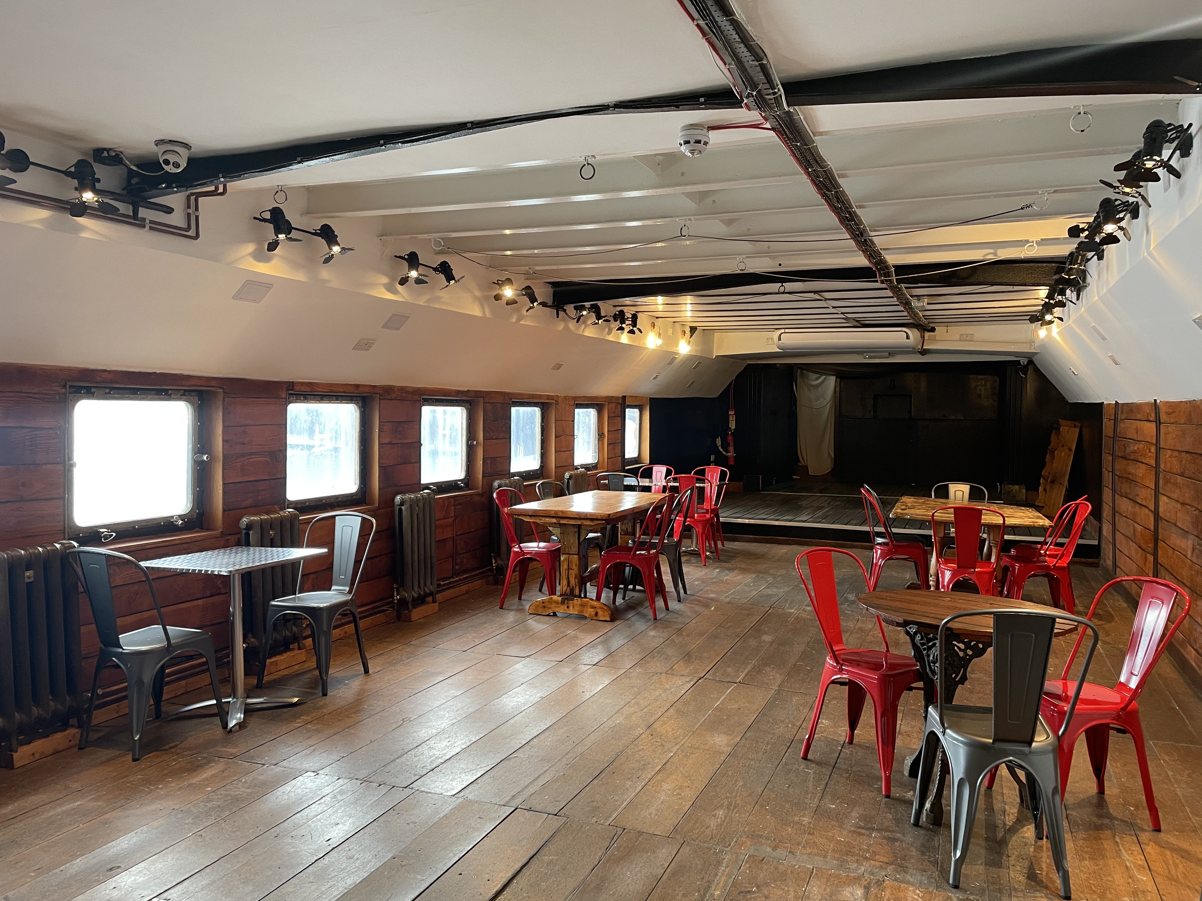 Lower Deck at Battersea Barge: rustic event space with wooden walls, ideal for gatherings.