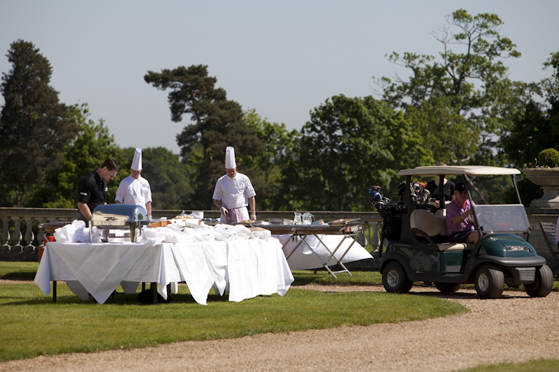 Outdoor catering setup at Stoke Park, featuring chefs and lush greenery for events.