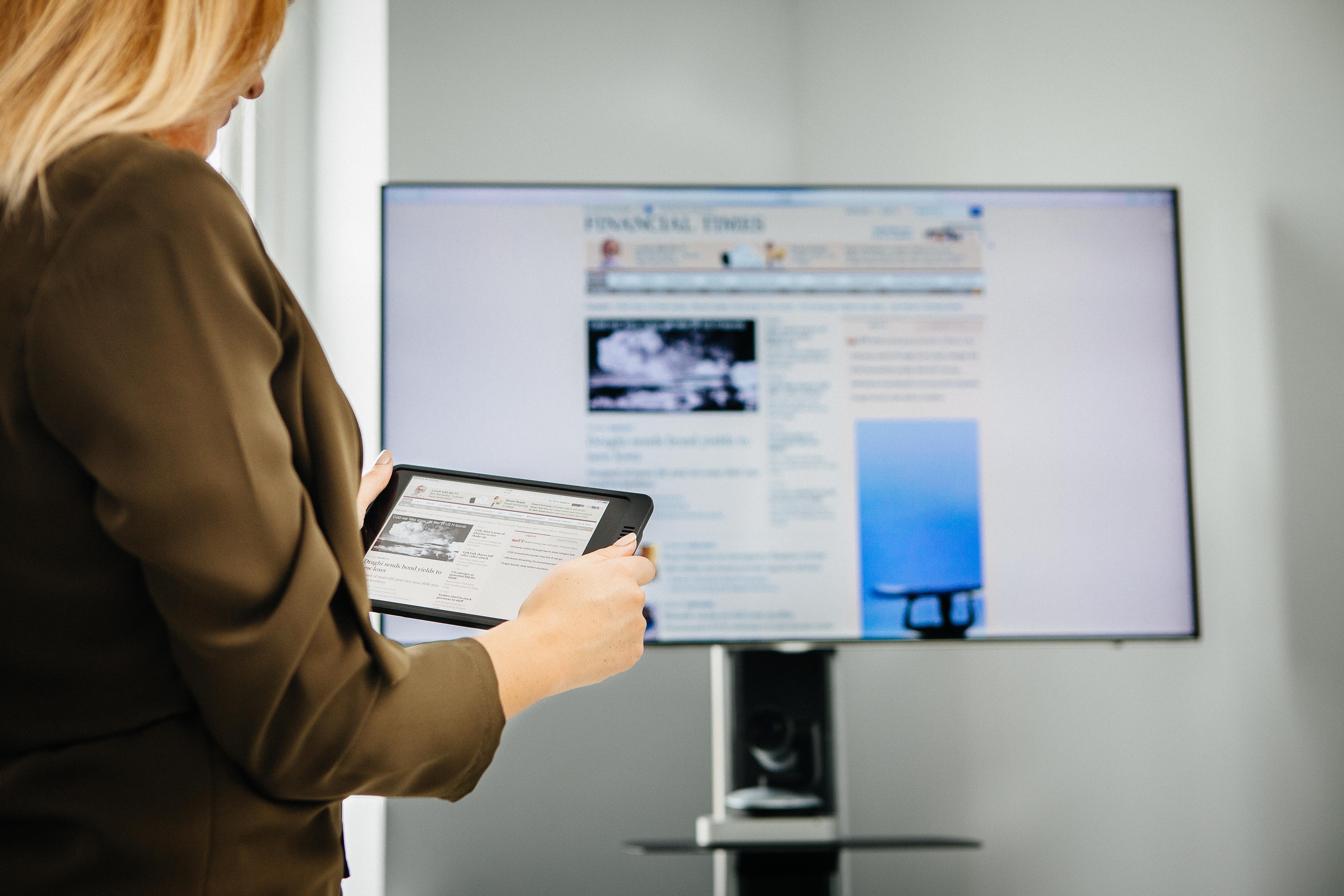 Hot Desks in Mayfair: Professional hybrid meeting with tablet and large screen.