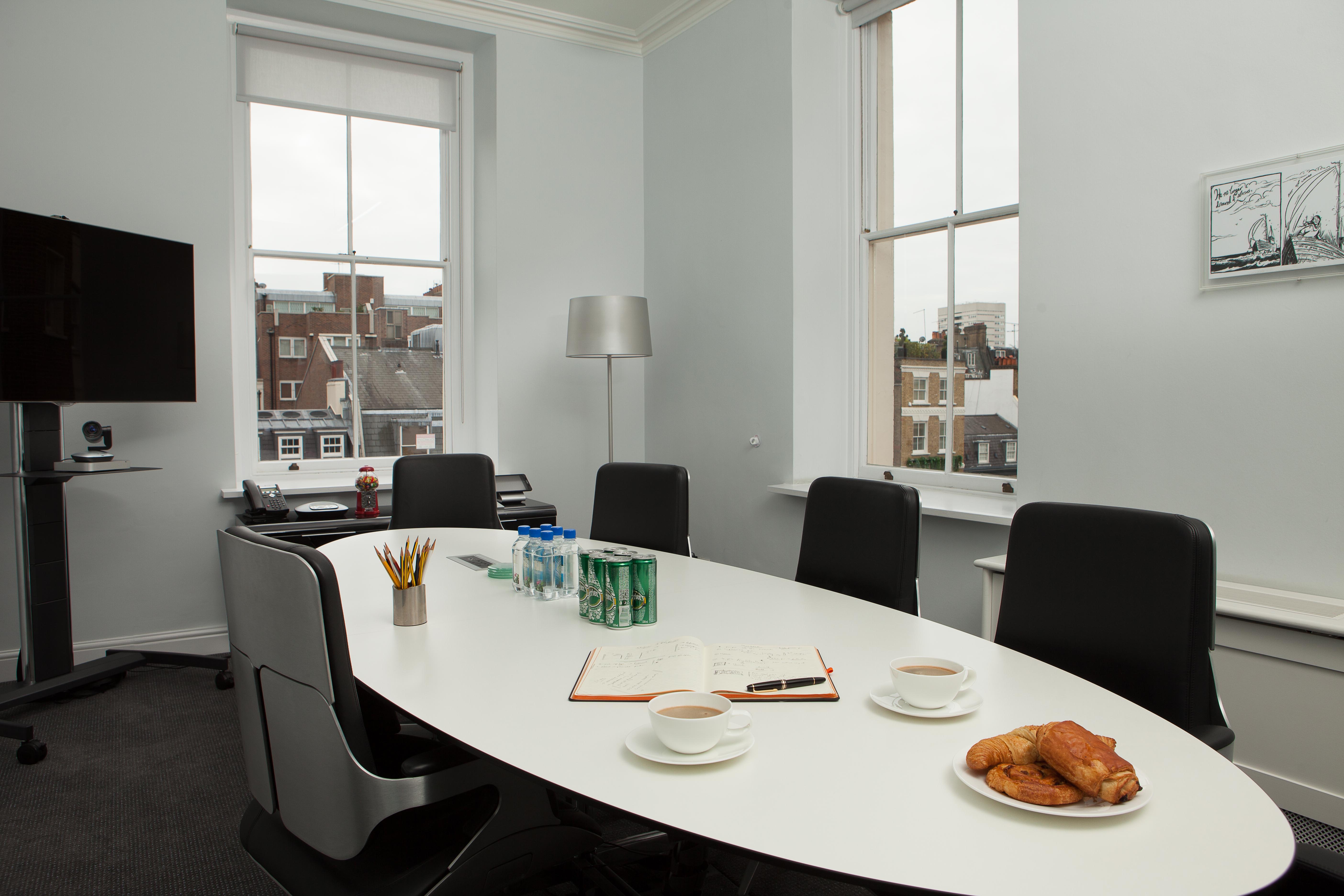 Hot Desks in Mayfair: modern meeting room with oval table, ideal for corporate events.