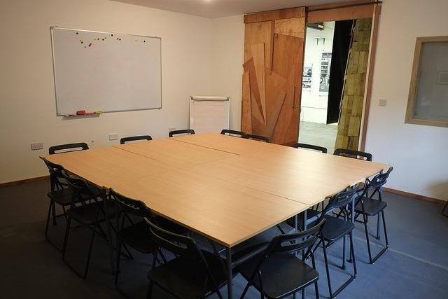 Versatile meeting room with large table, ideal for workshops and brainstorming sessions.