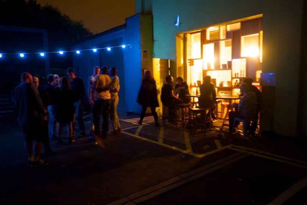 Outdoor networking event in vibrant meeting room with warm string lights.