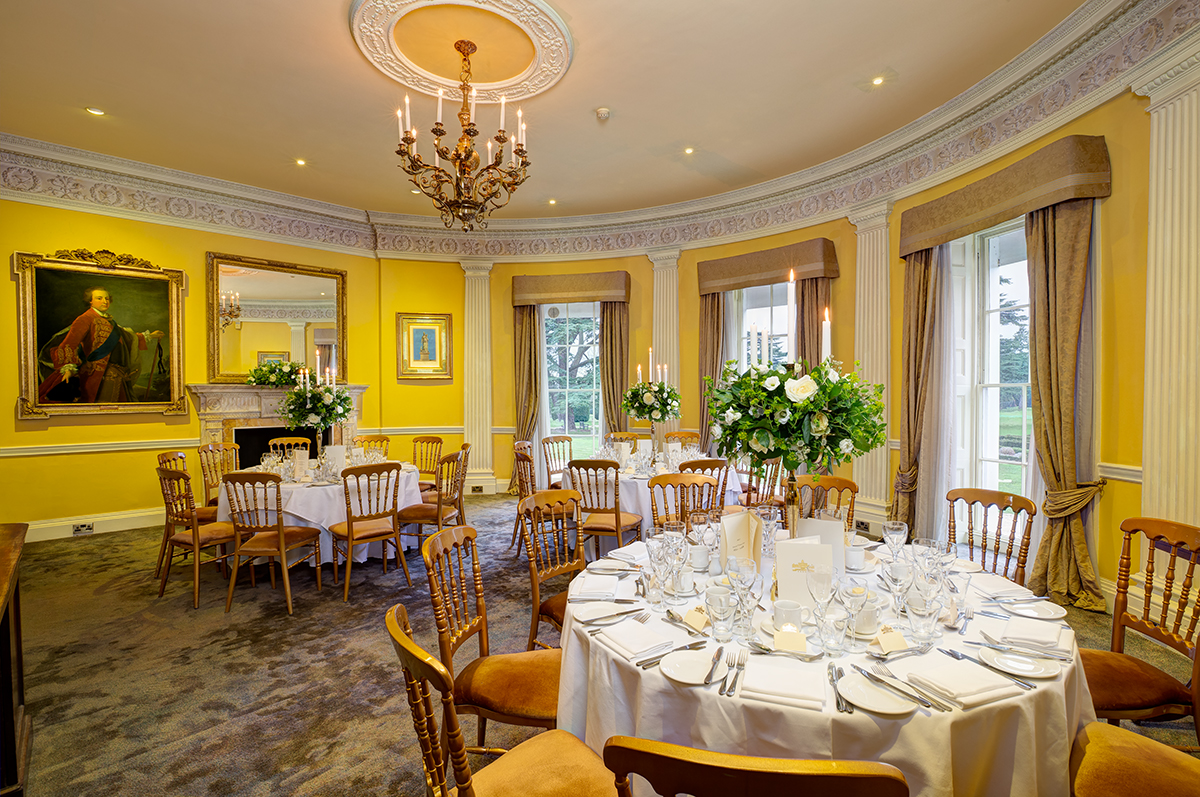 Elegant dining room with floral centerpieces for upscale events at Stoke Park.