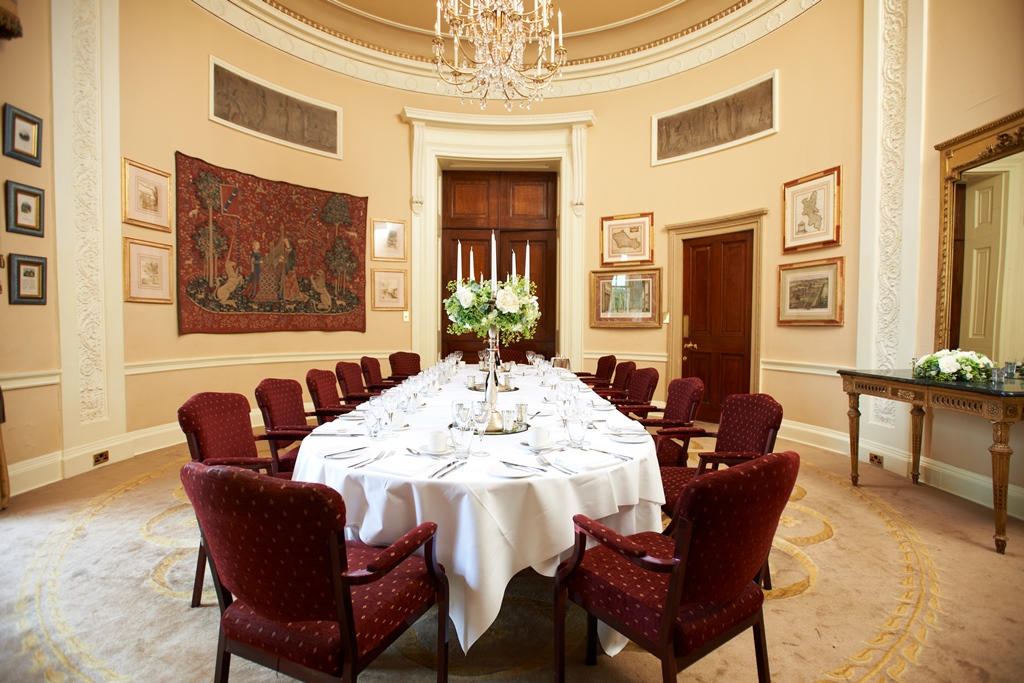 Elegant dining room at Stoke Park for formal events with floral centerpiece and fine tableware.