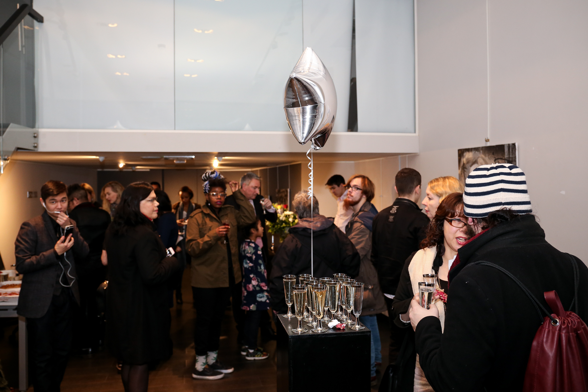 Networking event at Old Brompton Gallery with festive balloons and cocktails.