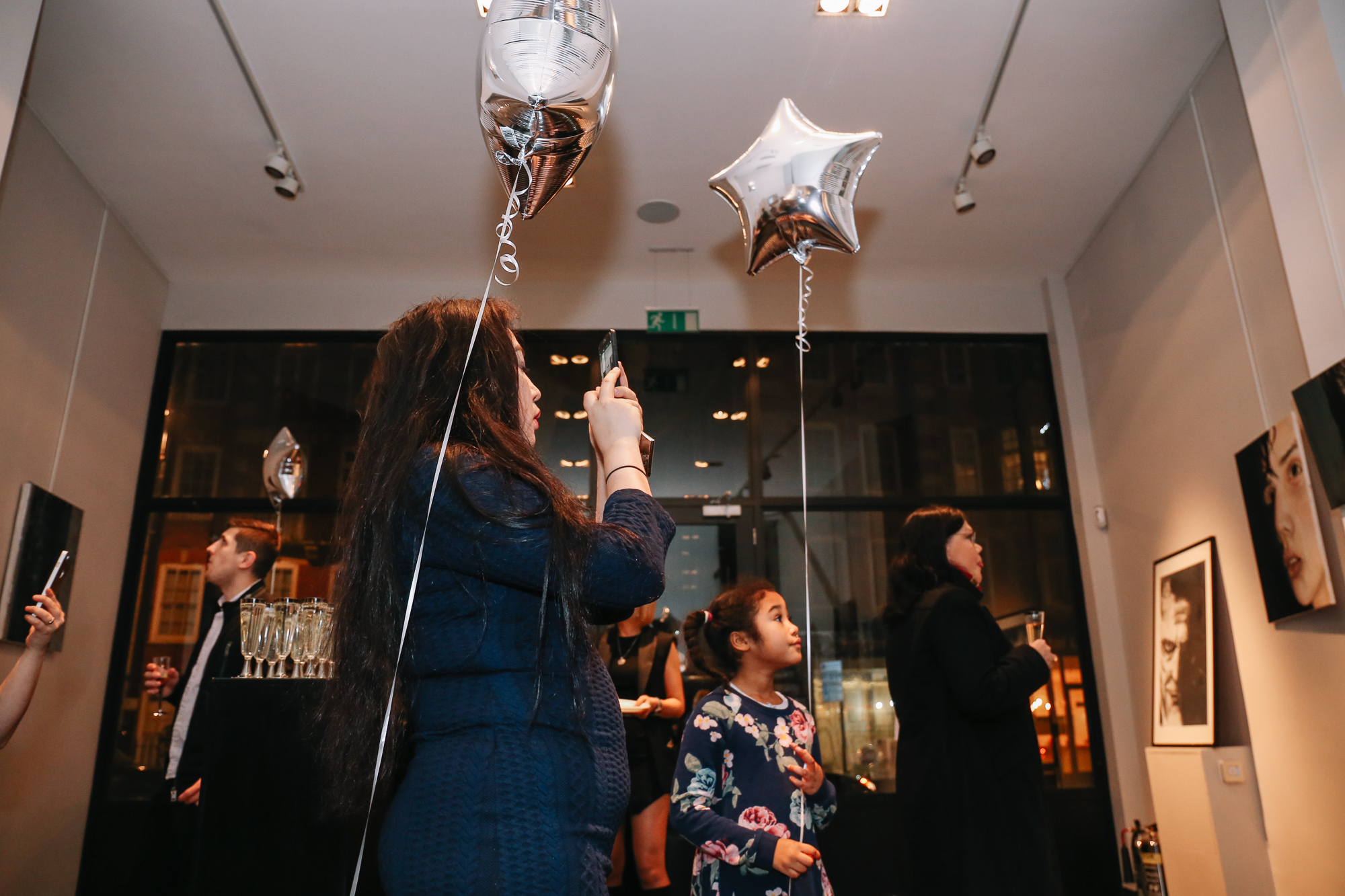 Old Brompton Gallery event with star-shaped balloons, family-friendly atmosphere, networking.