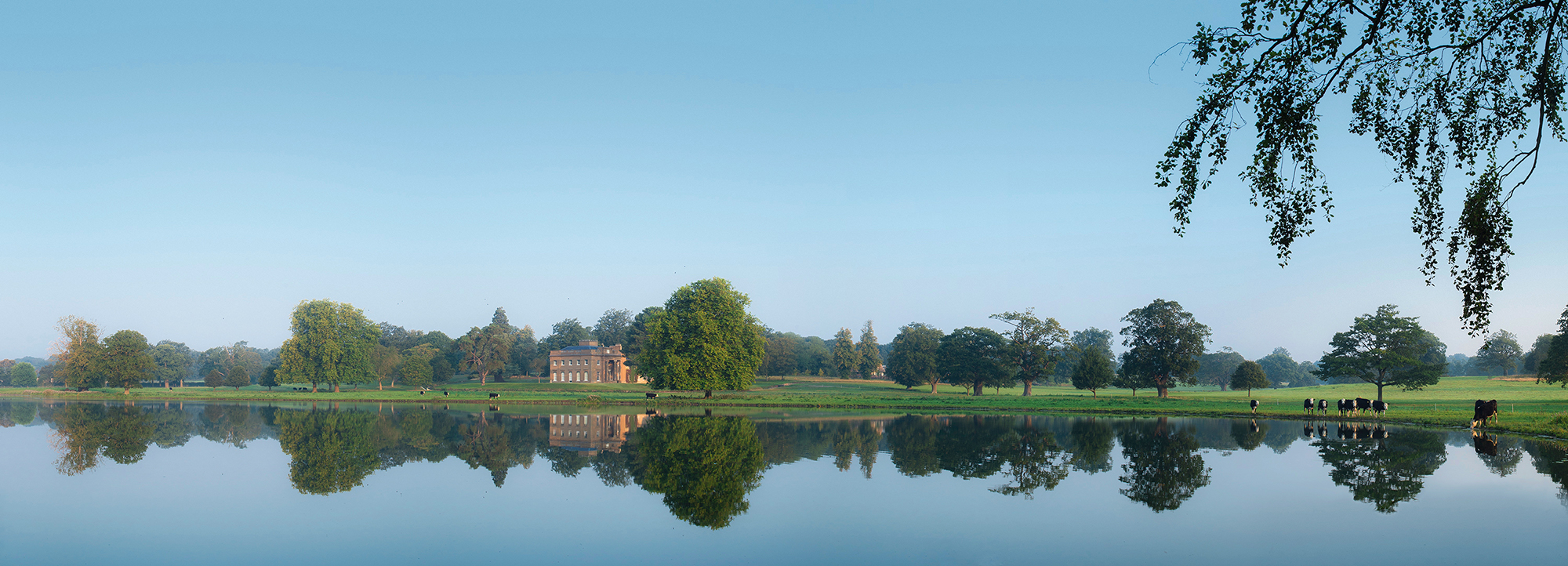 Exclusive Use Manor House by tranquil lake, ideal for weddings and outdoor events.