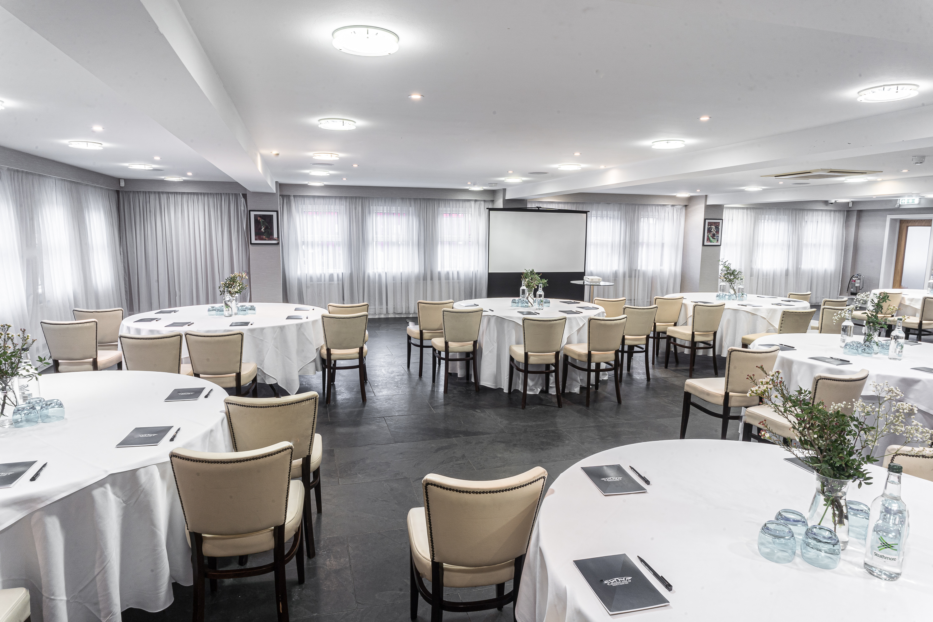 Speroni's Restaurant meeting space with round tables, ideal for workshops and seminars.