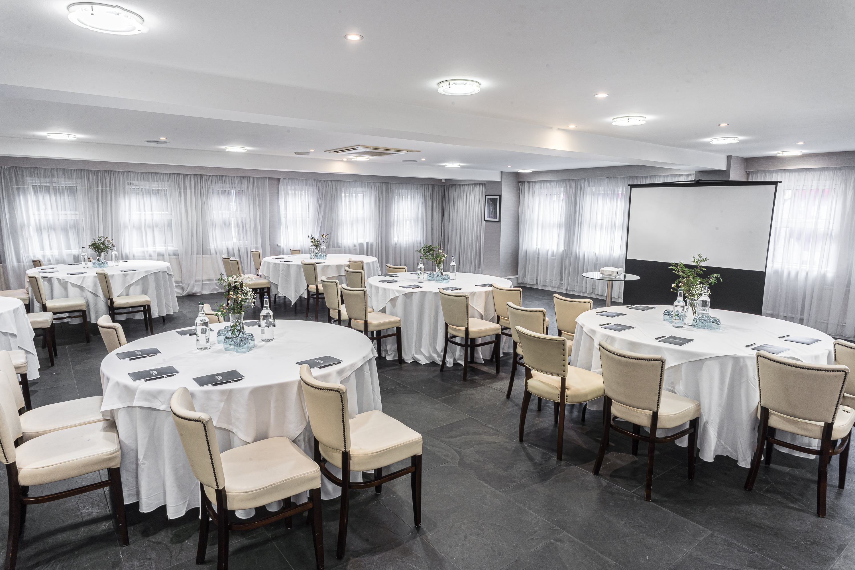 Speroni's Restaurant event space with elegant round tables, ideal for workshops and seminars.