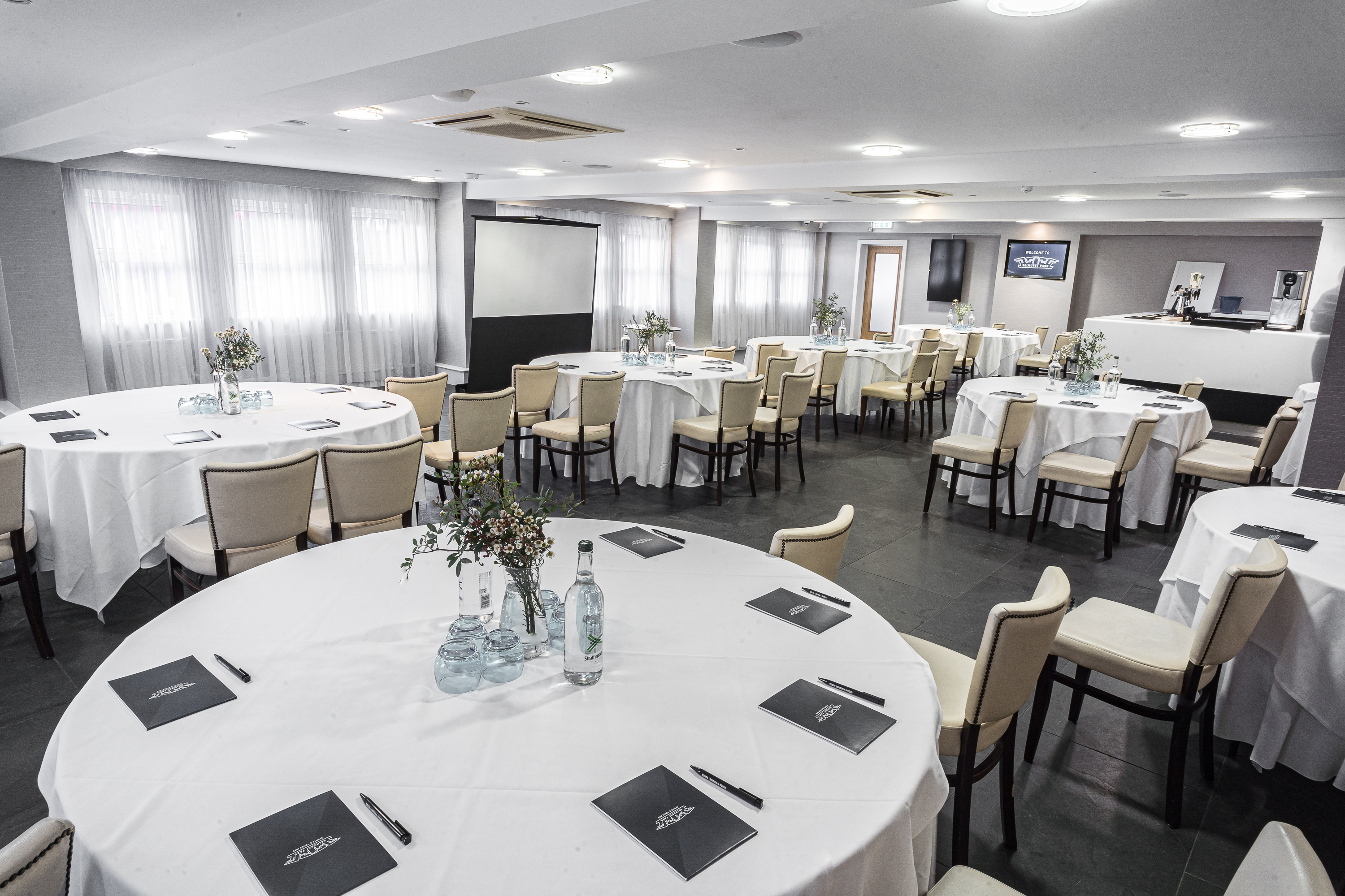 Speroni's Restaurant meeting space with round tables, ideal for corporate events and workshops.