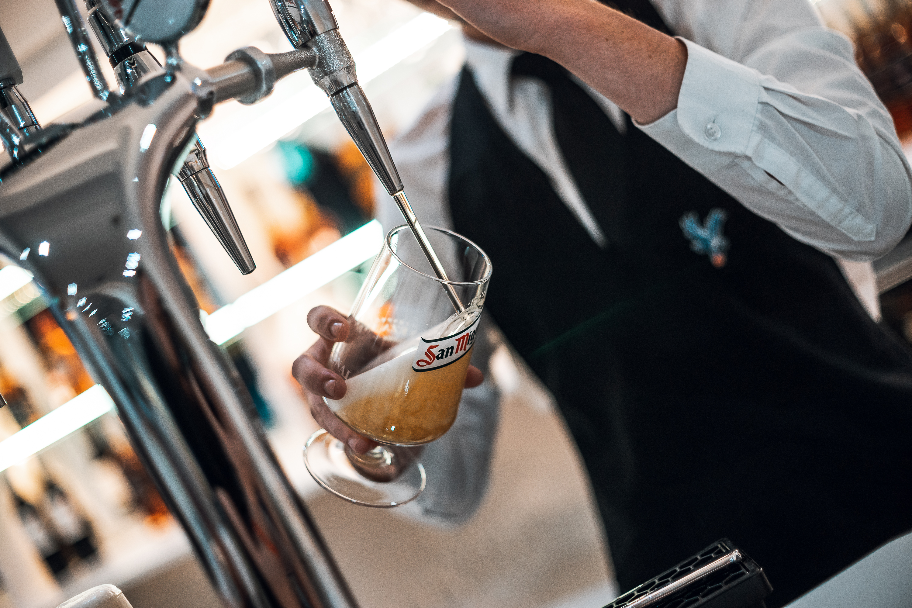 Bartender pouring draft beer at 2010 Club, Selhurst Park, enhancing event experience.