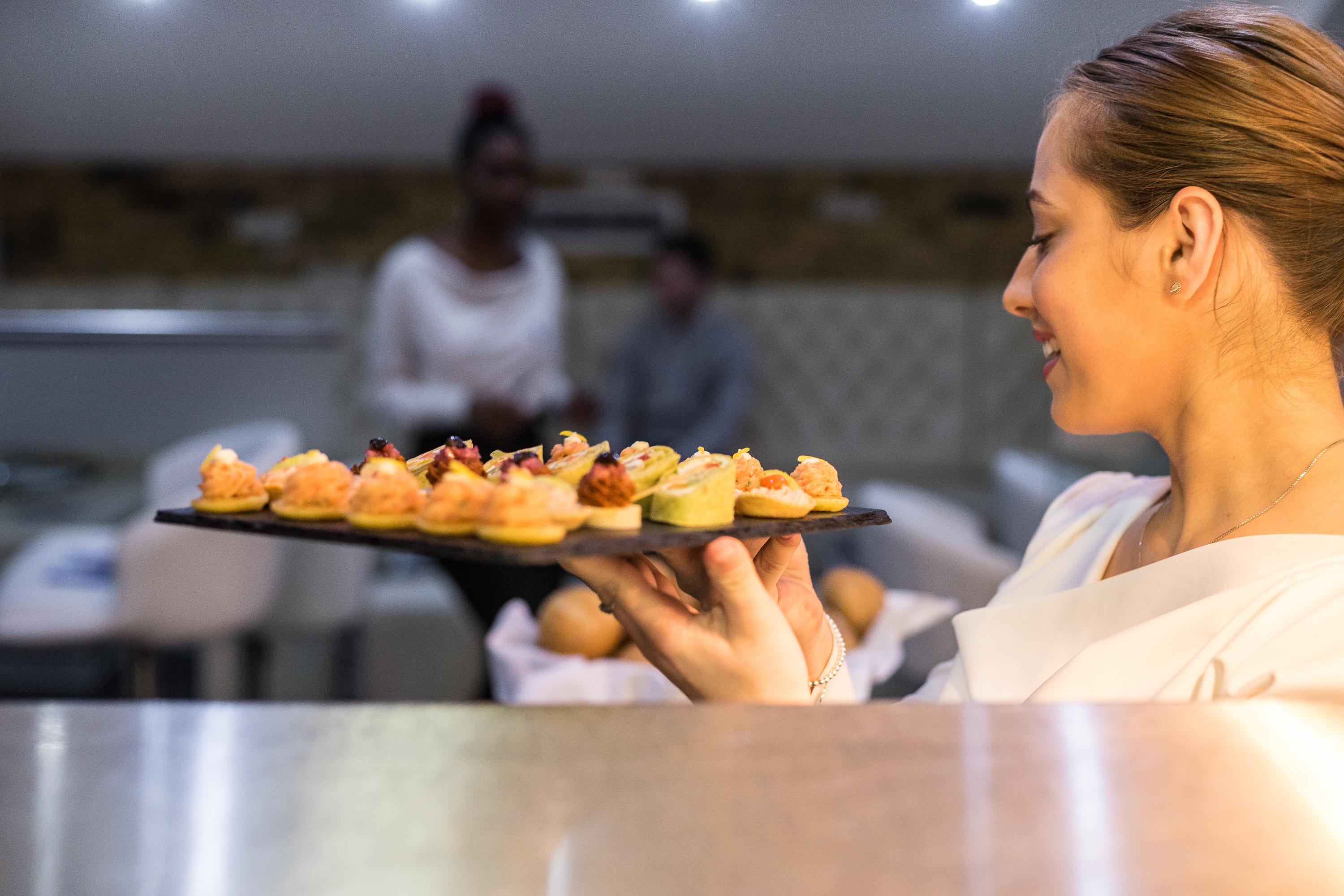 Catering professional presents elegant hors d'oeuvres at Crystal Palace event.