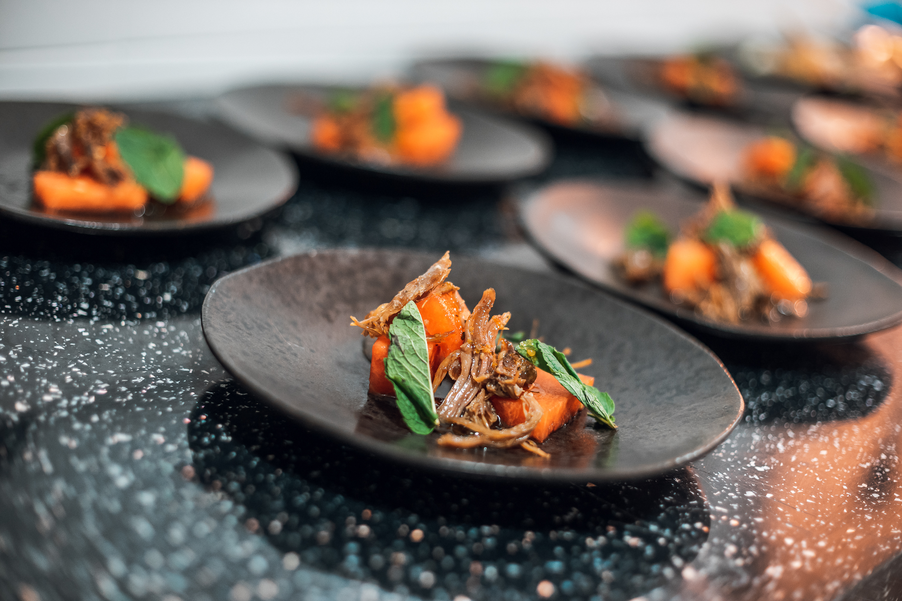 Elegant dish on black plate at Crystal Palace upscale event catering.