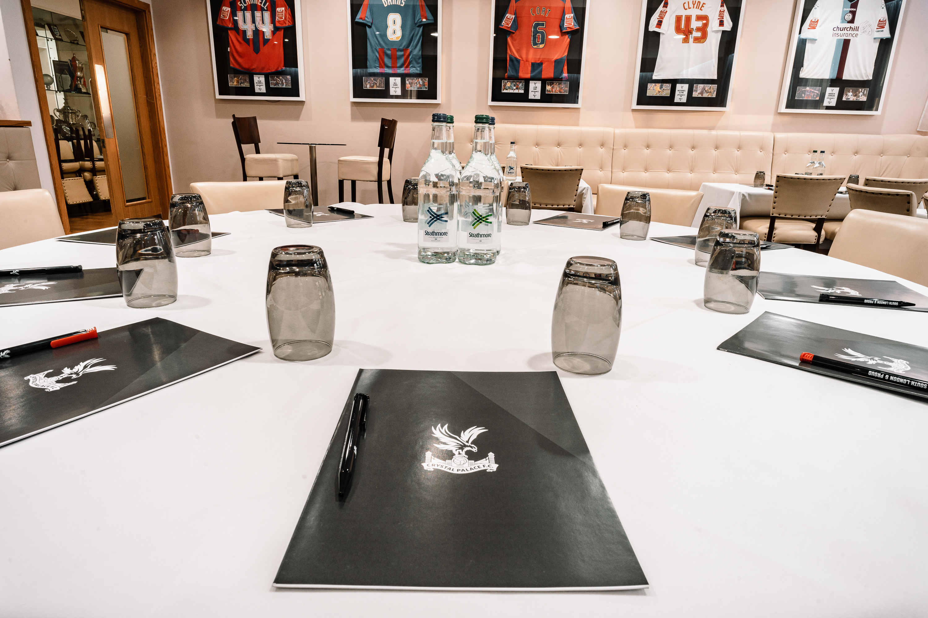 Vice President's Lounge at Selhurst Park with elegant meeting setup and framed jerseys.