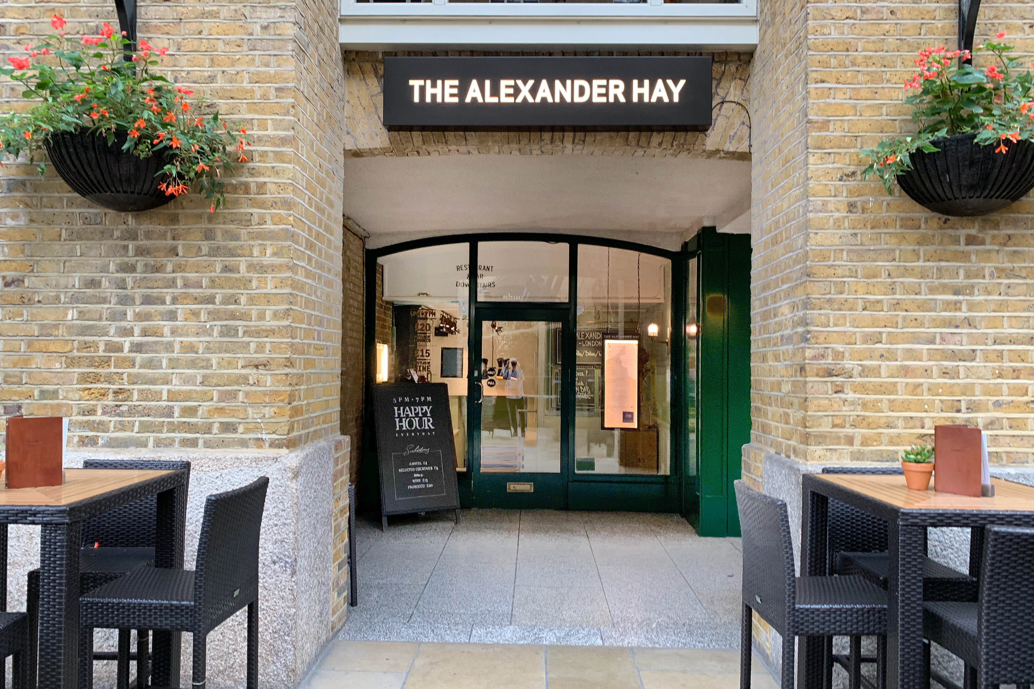 Welcoming entrance of The Alexander Hay with outdoor seating for networking events.