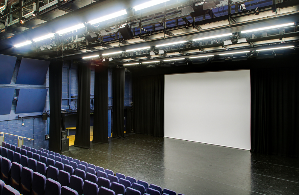 Lilian Baylis Studio stage with projection screen for events, workshops, and performances.