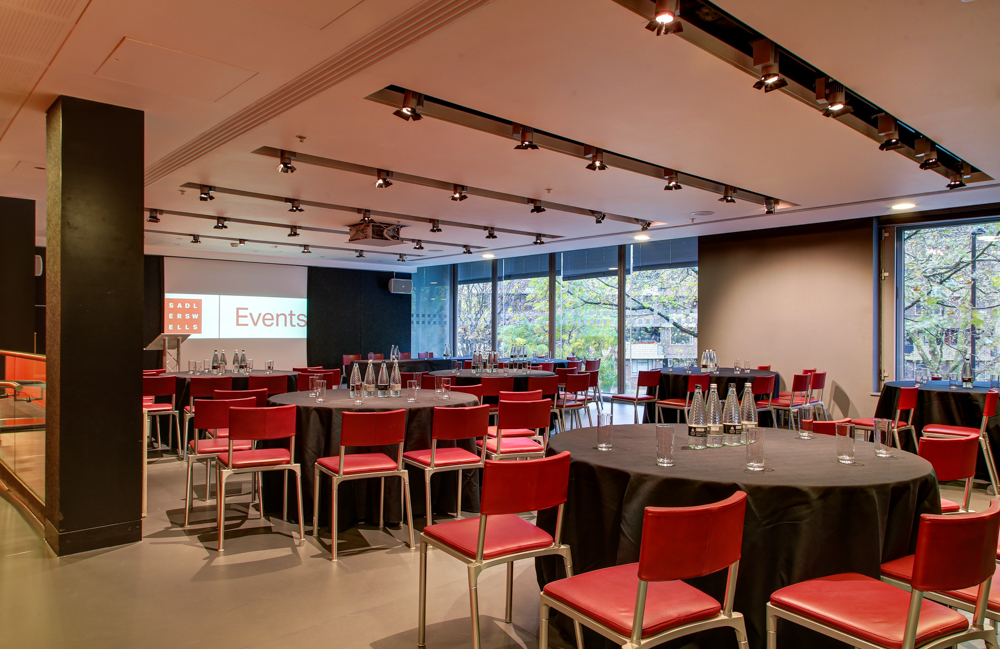 Dorfman Room at Sadler's Wells, set for corporate meeting with round tables and red chairs.